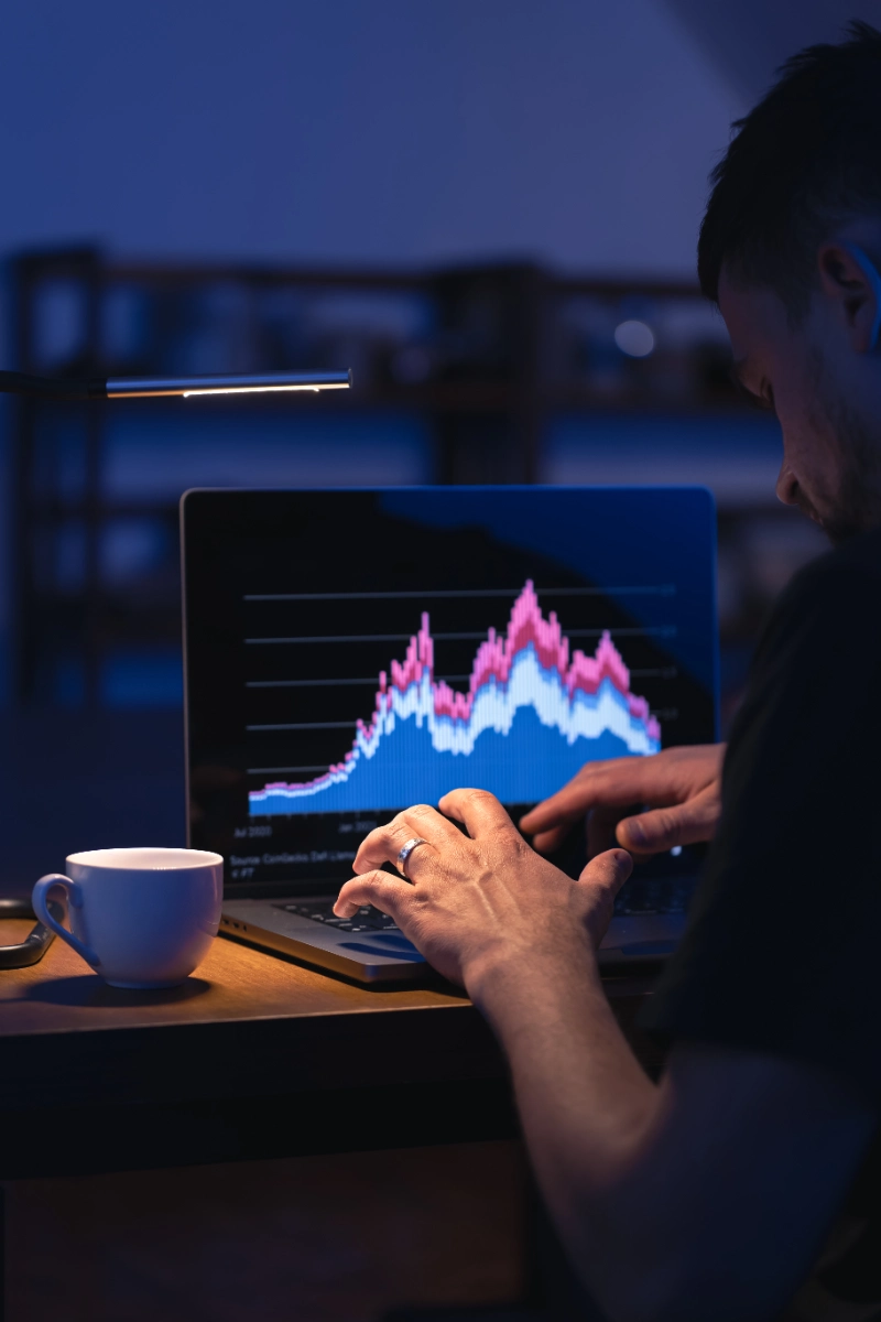 Bróker analizando gráficos de mercado en su laptop