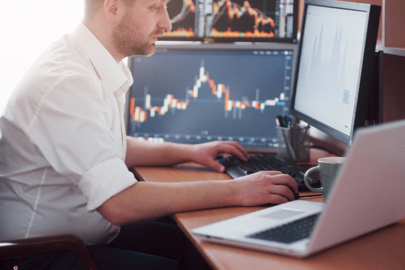 Sesgo de anclaje en trading: joven empresario mirando el monitor en su escritorio