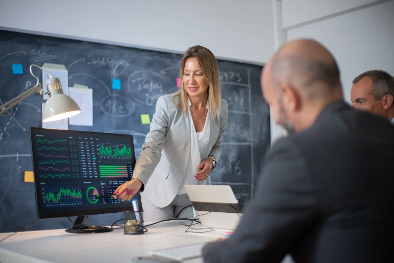 Psicología de equipos de trading: empleados analizando datos de mercado en pantalla