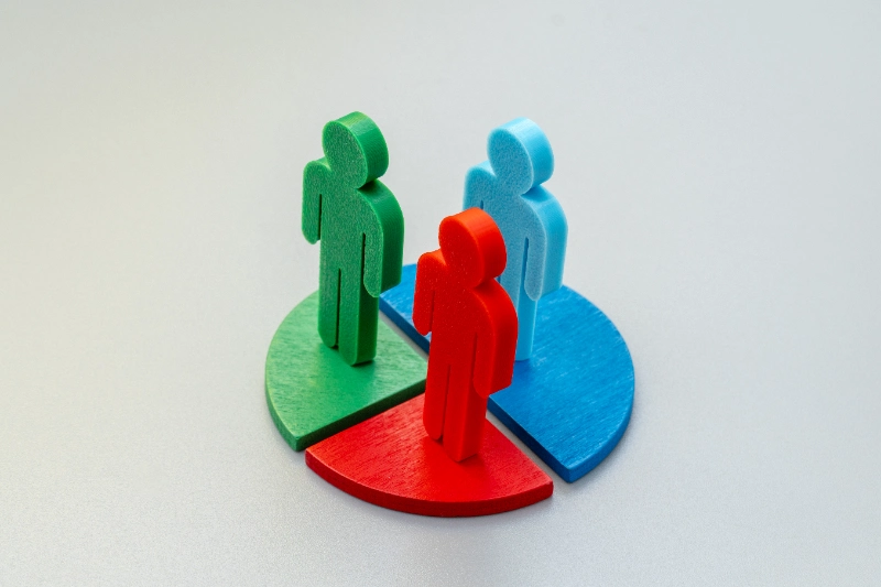 Comparación social en trading: figuras humanas sobre segmentos de un gráfico circular representando distribución y comparación