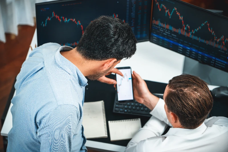 Sesgo de confirmación en trading: inversor analizando el tipo de cambio en su smartphone