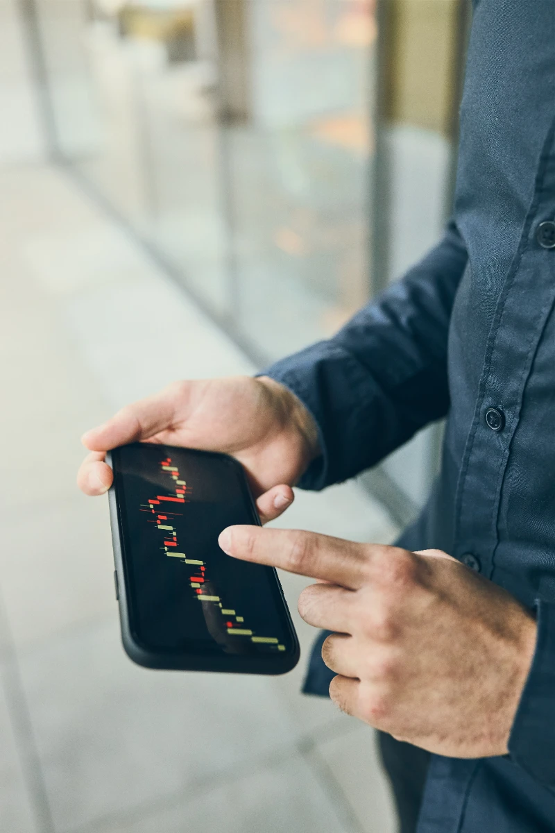 Persona invirtiendo en criptomonedas desde una aplicación en su smartphone