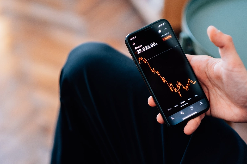 Persona revisando estadísticas de criptomonedas en su teléfono