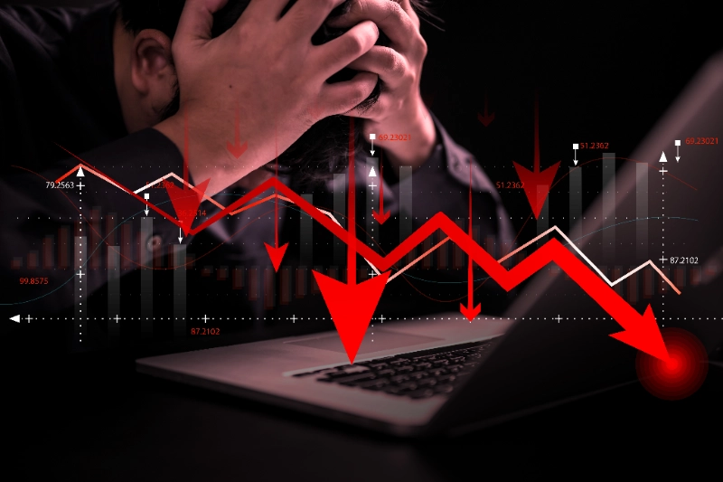 Aversión a la pérdida en trading: hombre de negocios estresado ante gráficos que muestran pérdidas