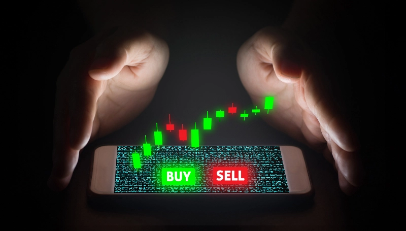 Mano de un hombre operando con trading a través de una pantalla virtual en el smartphone