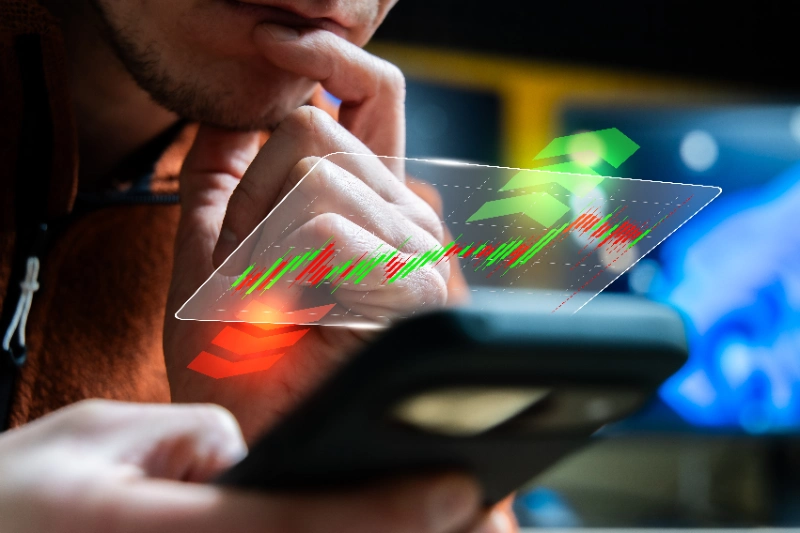 Inversor analizando gráficos del mercado bursátil desde su smartphone