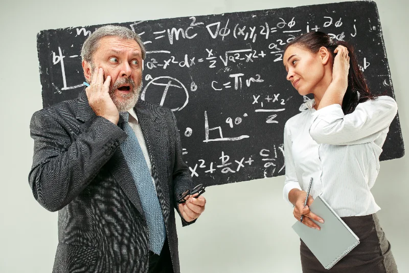Profesor y estudiante frente a una pizarra en un aula, ilustración de tasa de acierto y expectativa matemática