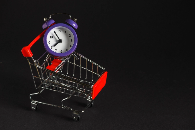 Carrito de compras con un reloj despertador, concepto de horario