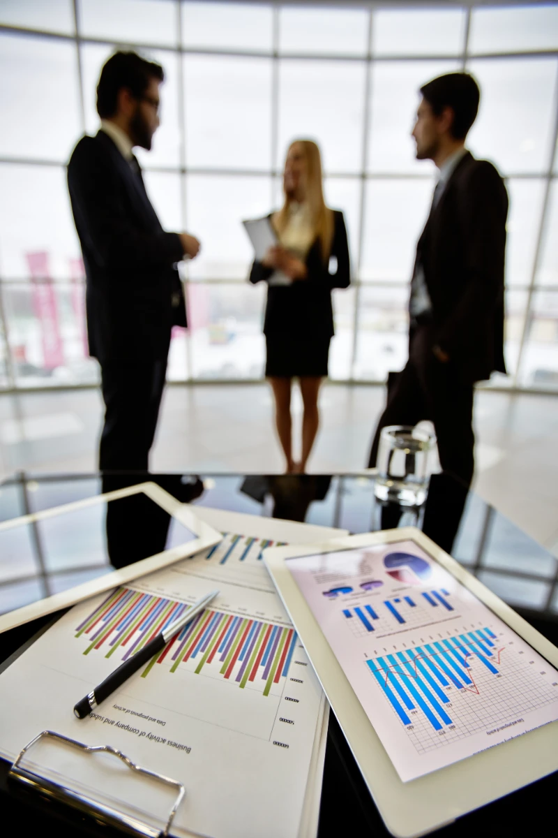 Documentos estadísticos y gráficos de mercado sobre una mesa de oficina
