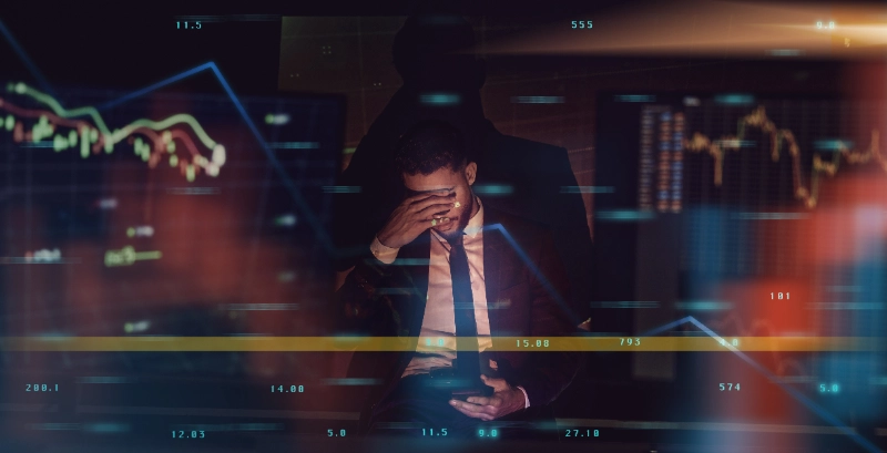 Trader estresado con dolor de cabeza frente a su móvil con gráficos superpuestos